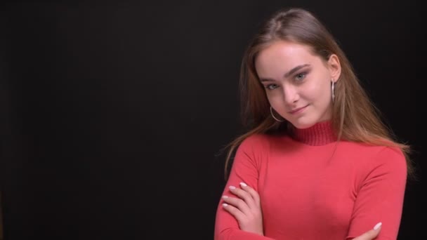 Closeup portrait of young beautiful caucasian female model having her arms crossed and being shy looking at camera — Stock Video