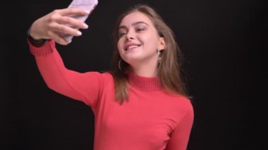 Neşeyle selfies telefonda alarak ve mutlu bir şekilde saçlarını savurma genç beyaz güzel kadın portresi portre