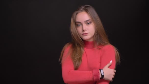 Closeup portret van de jonge mooie Kaukasische vrouwelijke model poseren voor de camera met geïsoleerd op zwarte achtergrond — Stockvideo