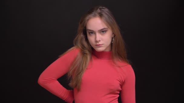 Крупним планом портрет молодої кавказької красивої жіночої моделі позує перед камерою, маючи одну руку на стегні і з нетерпінням чекаючи — стокове відео
