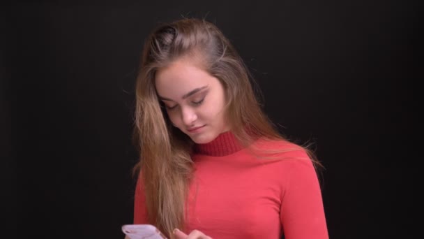 Primer plano retrato de joven hermosa morena hembra navegando por el teléfono a continuación, mirando a la cámara y sonriendo felizmente — Vídeo de stock