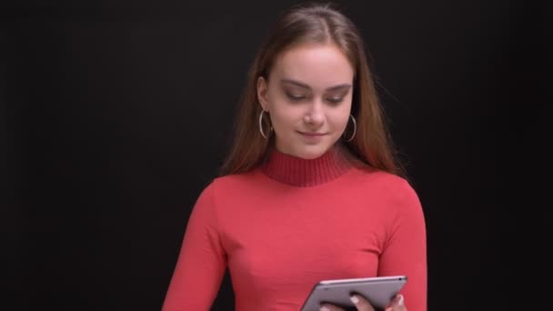 Крупный план портрета молодой кавказской женщины, использующей планшет и показывающей зеленый экран на камеру — стоковое видео