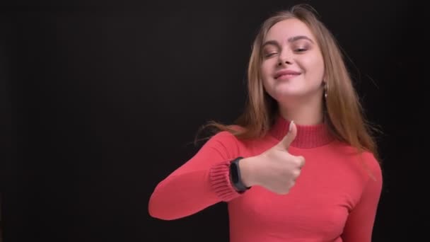 Closeup portrait of young caucasian beautiful female showing thumb up and gesturing while looking at camera and smiling — Stock Video