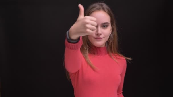 Closeup portrait of young caucasian beautiful female confidently showing thumb up while looking at camera and smiling — Stock Video