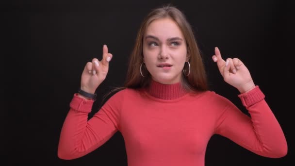 Closeup portrait of young beautiful caucasian female being anxious and having her fingers crossed — Stock Video