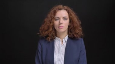 Kameraya bakarak kırmızı kıvırcık saçlı yetişkin ciddi beyaz iş kadını closeup portresi