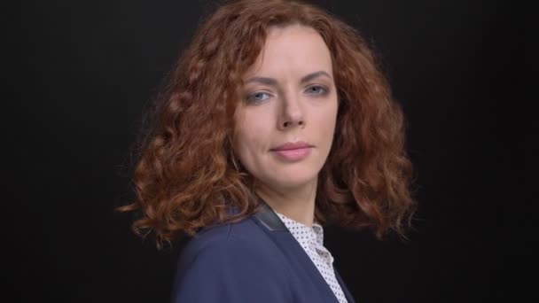 Detailní portrét dospělých jistý bělošský podnikatelka otáčení a při pohledu na fotoaparát s izolované na černém pozadí — Stock video