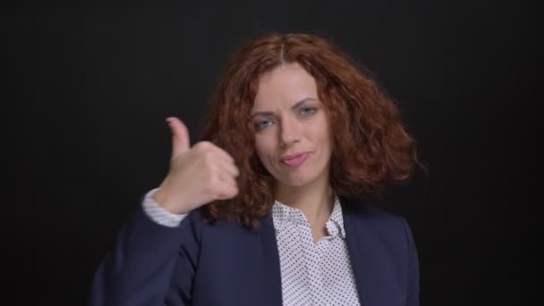 Nahaufnahme Porträt einer jungen kaukasischen Geschäftsfrau, die selbstbewusst den Daumen nach oben zeigt, während sie in die Kamera blickt — Stockvideo