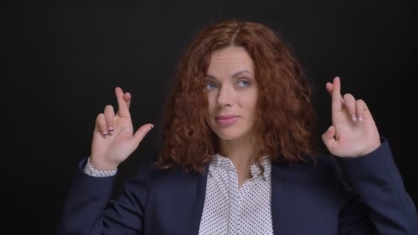 Retrato de close-up de uma mulher caucasiana adulta nervosa e com os dedos cruzados na frente da câmera — Vídeo de Stock