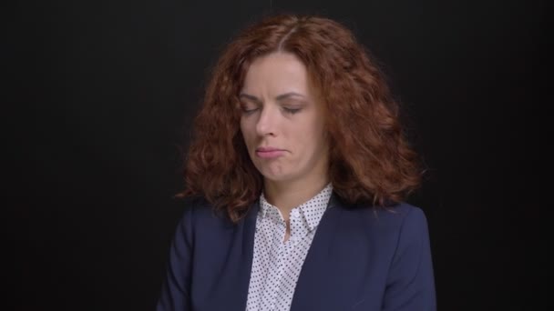 Nahaufnahme Porträt einer erwachsenen kaukasischen Frau mit roten lockigen Haaren, die verärgert und enttäuscht in die Kamera blickt — Stockvideo
