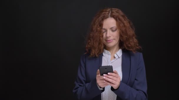 Closeup portret van volwassen Kaukasische zakenvrouw browsen op de telefoon voor de camera — Stockvideo