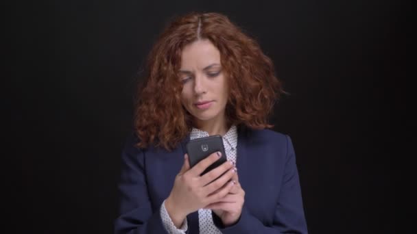 Portret zbliżenie dorosły kaukaski kobieta z rude włosy kręcone wyświetlanie selfie zrobione przez telefon, a następnie patrząc na kamery — Wideo stockowe