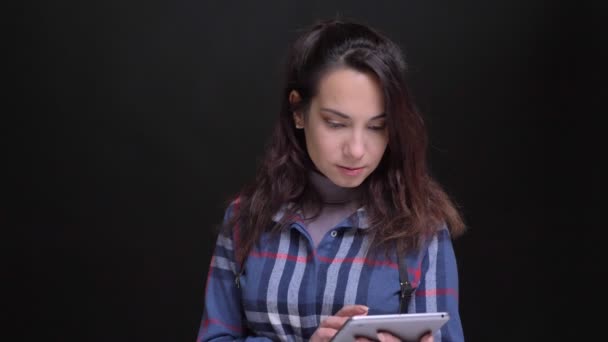 Nahaufnahme Porträt einer jungen schönen kaukasischen Frau, die auf dem Laptop tippt, sich dann der Kamera zuwendet und lächelt — Stockvideo
