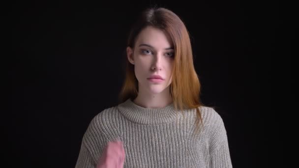 Closeup retrato de jovem modelo feminino caucasiano encantador olhando em linha reta e fixando seu cabelo posando na frente da câmera — Vídeo de Stock