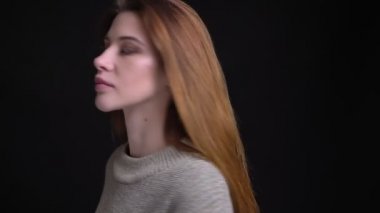 Genç güzel beyaz kadın gülümseyerek ve bir göz wink yapma kameraya bakarak çırpınan onun saç etrafında dönen Closeup portresi.