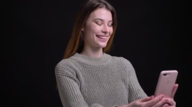 Video aramasý telefonda olması ve neşeyle kamera önünde gülümseyen genç beyaz kadın portresi portre