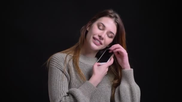 Крупный план портрета молодой кавказской женщины, звонящей по телефону и смеющейся перед камерой — стоковое видео