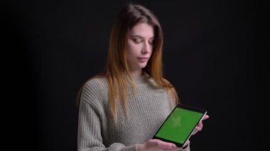 Tablet kullanma ve yeşil renk tuşlu ekran kamera için gösterilen genç güzel beyaz kadın portresi portre