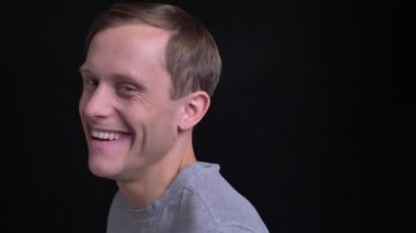 Rto kamera dönüm ve izole siyah arka plan ile mutlu bir şekilde gülerek genç çekici beyaz adam portresi portre