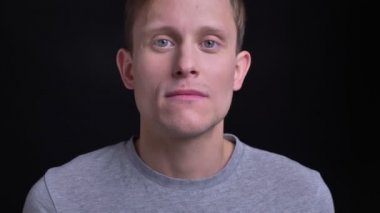 Portre portre genç çekici beyaz erkek yüz gri gözleri doğrudan kameraya gülümseyen yüz ifadesi ile seyir