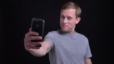 Portre portre genç çekici beyaz adamın selfies telefonda yapma