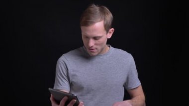 Tablet kullanma ve yeşil renk ekran kamera için gösterilen genç yakışıklı beyaz adam portresi portre.