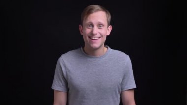 Doğruca kameraya ararken heyecan ile gülümseyen genç çekici beyaz bir adam portresi portre