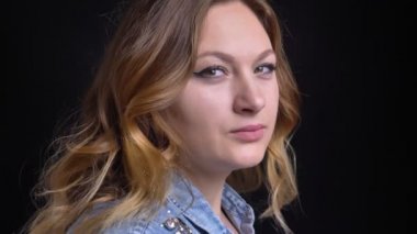 Taraftan dönüm ve arka plan üzerinde siyah izole kameraya bakarak yetişkin beyaz kadın portresi portre