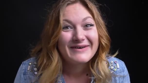 Close-up macro portret van volwassen Kaukasische vrouw opgewonden praten met camera lacht vrolijk met de geïsoleerd op zwarte achtergrond — Stockvideo