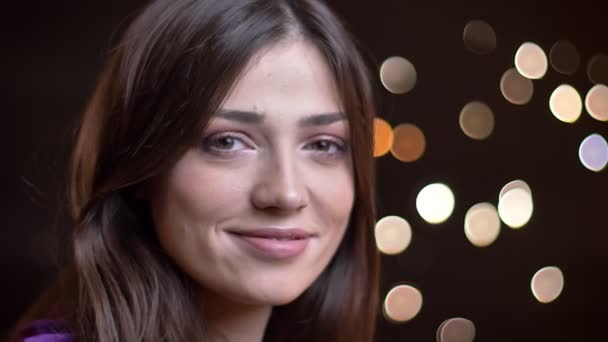 Closeup boční pohled portrét mladých docela Kavkazský žena soustružení s úsměvem a pózování před kamerou s zasněný výraz obličeje — Stock video