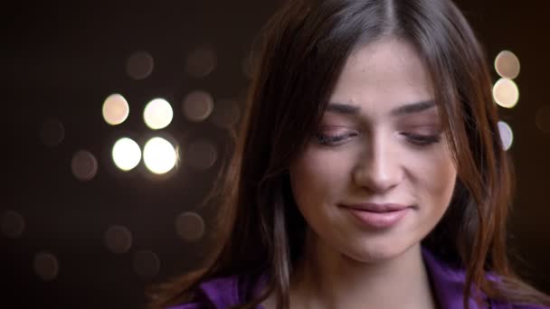 Closeup portret van jonge mooie Kaukasische vrouw krijgen verlegen en die betrekking hebben op haar gelukkig glimlach met handen speels draaien — Stockvideo