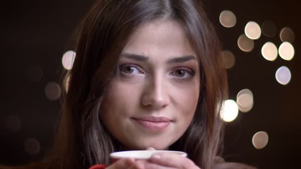 Gros plan portrait de jeune belle femme caucasienne ayant une tasse de thé chaud souriant et regardant la caméra — Video