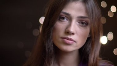Gece ile doğrudan kameraya bakarak uzun kahverengi saçlı genç oldukça beyaz kadın portresi closeup arka plan üzerinde ışıklar