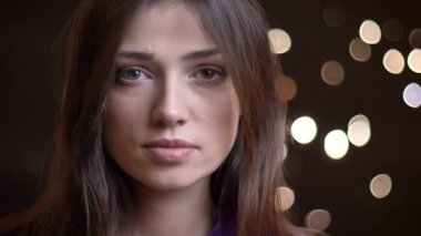 Doğruca kameraya gece ile genç oldukça beyaz kız portresi closeup arka plan üzerinde ışıklar.