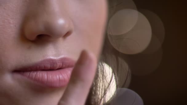 Closeup portret van de jonge Kaukasische vrouw lippen. Vrouw zetten een vinger op de lippen aangedrongen stilte — Stockvideo