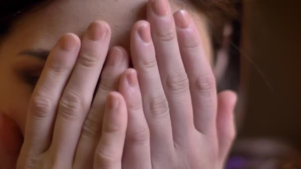 매력적인 젊은 백인 여성의 손으로 그녀의 얼굴을 숨기고 하 고 흥분으로 드러내는 근접 촬영 초상화 — 비디오