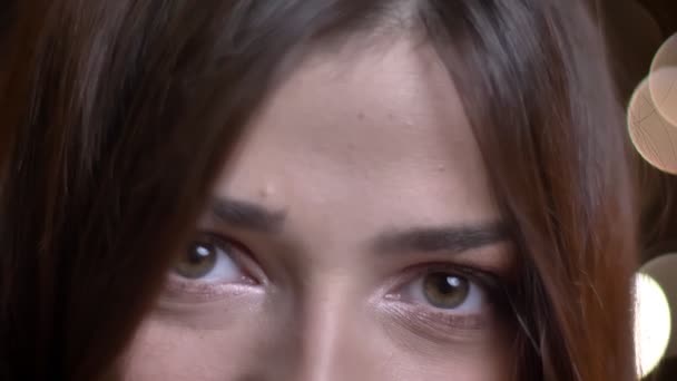 Primo piano ritratto di giovane bella faccia femminile caucasica con gli occhi verdi facendo uno sguardo misterioso alla macchina fotografica — Video Stock