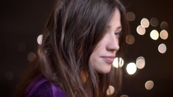 Closeup portrait of young caucasian female turning to camera with her hair being fluttered by the wind looking straight and smiling — Stock Video