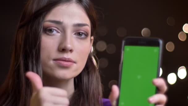 特写镜头肖像年轻漂亮的高加索女性使用手机显示绿色屏幕相机和手势拇指 — 图库视频影像