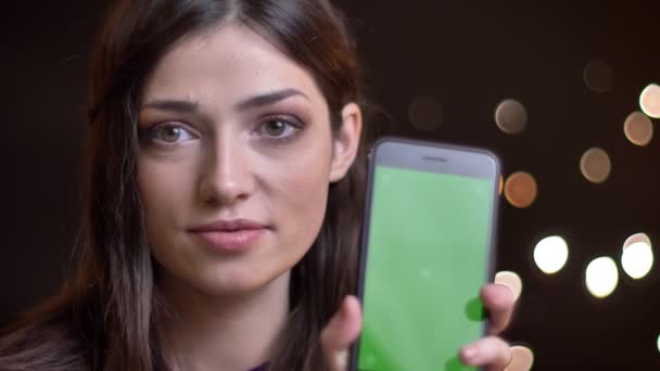 特写镜头的年轻美丽的高加索女性的特写镜头肖像显示手机的绿色屏幕相机和微笑 — 图库视频影像