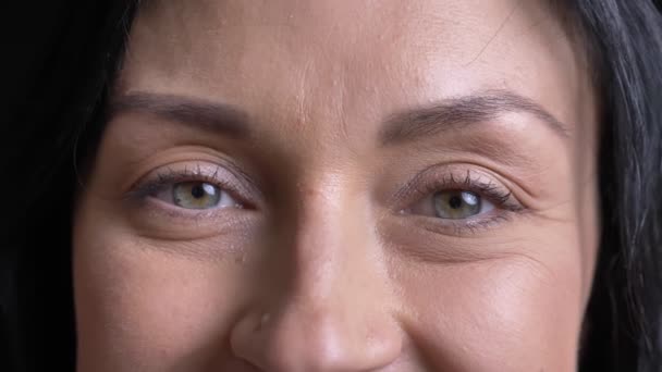 Крупним планом портрет красивого дорослого кавказького жіночого обличчя з сірими очима дивиться на камеру з усміхненим виразом обличчя — стокове відео