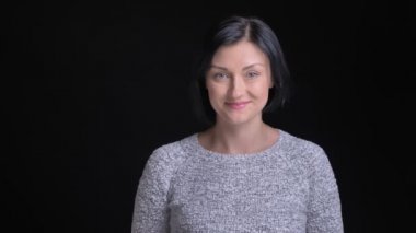 Kısa siyah saçlı dudaklarını yalamaya ve seductively doğruca kameraya bakarken gülümseyen genç güzel beyaz kadın portresi portre