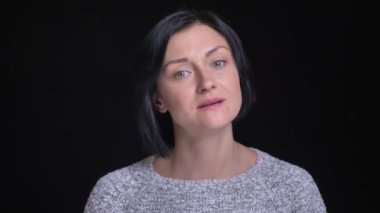 Gülümseyen ve dikkatle izole siyah arka plan ile kameraya bakarak genç güzel beyaz kadın portresi portre