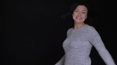 Portre portre yetişkin güzel beyaz kadın atlama ve doğruca kameraya bakarak gülen ve having fun çevresinde dönüm