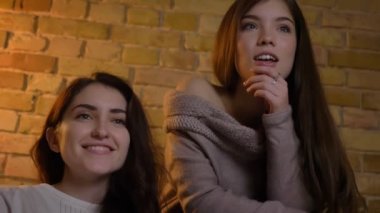 Birlikte oturan ve rahat ev atmosferi büyük ilgi ile film izlerken genç beyaz kız portresi.