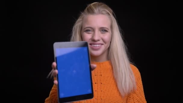 Nahaufnahme einer jungen hübschen kaukasischen Frau, die das Tablet benutzt und der Kamera den blauen Chroma-Schlüsselbildschirm zeigt — Stockvideo