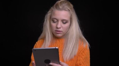 Genç oldukça beyaz kadın tablet üzerinde arka plan üzerine siyah izole ile tarama portre çekimi