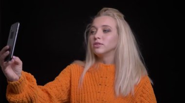 Video aramasý izole siyah arka plan ile konuşurken telefon sahip genç oldukça beyaz kadın portre çekimleri