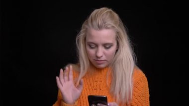 Closeup çekim alınan selfies telefonda görüntüleme sonra kameraya bakıyor ve gülümseyen genç oldukça beyaz kadın