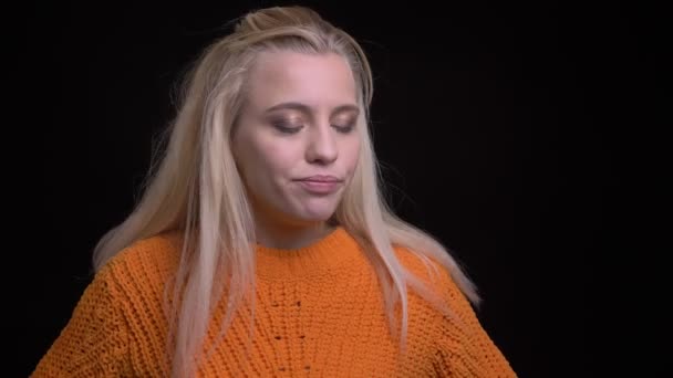 Close-up opnamen van jonge mooie Kaukasische vrouw met lang blond haar zwaaien haar hoofd teken onenigheid voor de camera — Stockvideo